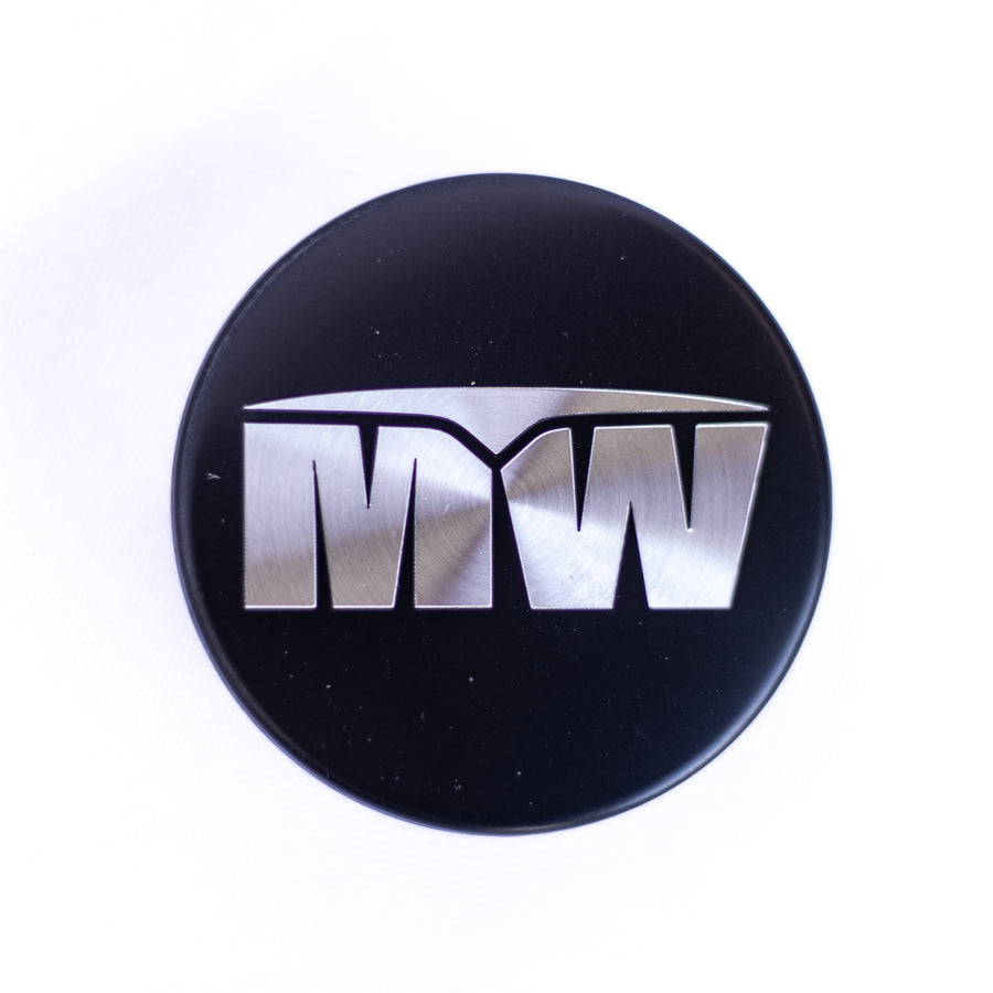 Tapa central: logotipo MW de aluminio cepillado (única)